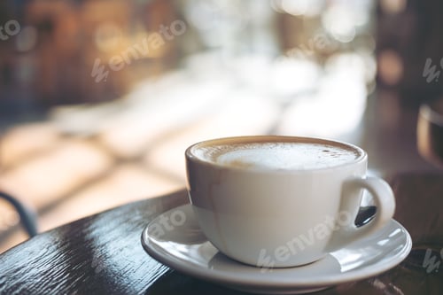 Preview: A cup of hot latte coffee on vintage wooden table