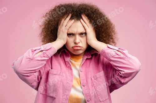 Preview: Upset tired woman with curly hair having headache, got bad news, looking at camera