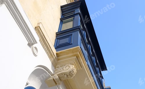 Preview: Bottom up view of the blue wooden balcony with stucco. Exterior of typical maltese houses.