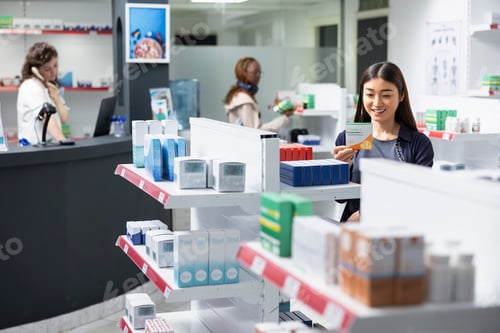 Preview: Asian client in a modern drugstore looks through pharmacy products