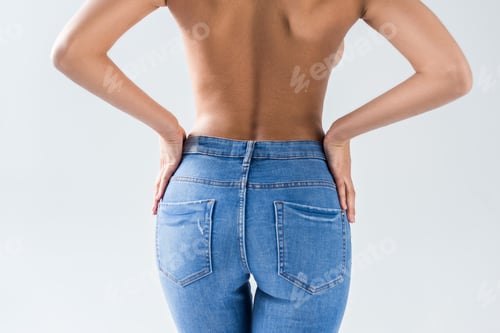 Preview: Cropped view of nude sexy woman in jeans on grey background