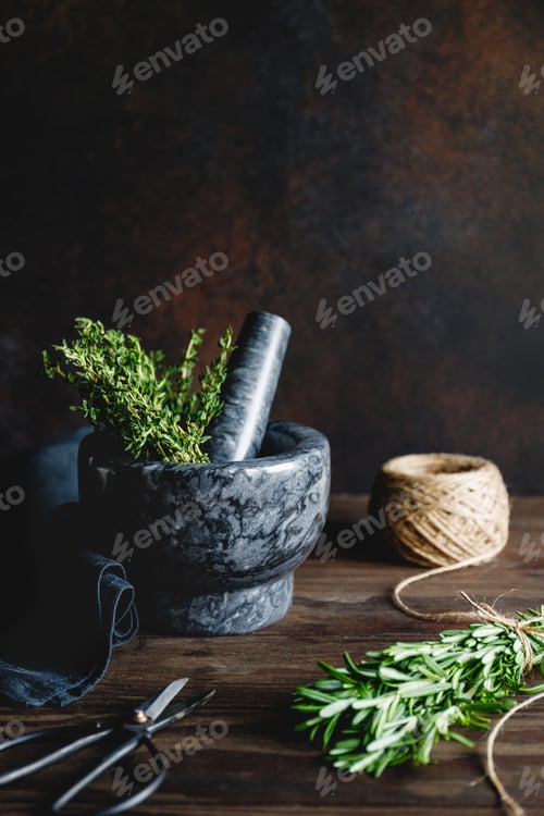 Preview: Fresh herbs in a marble mortar on a table