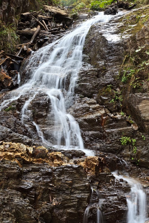 Preview: Waterfall Flowing Over Rocky Terrain in Nature