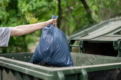 Preview: male dumping waste package into a big trash bin containers