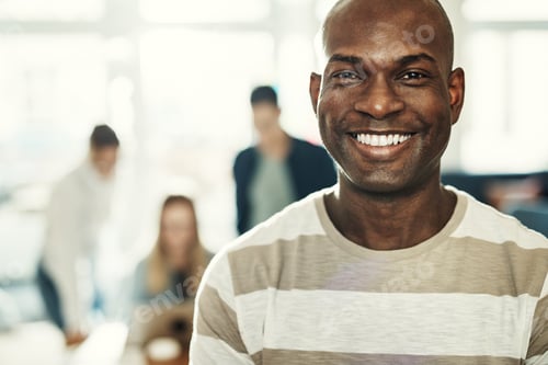 Preview: Confident young African designer standing in a modern office smiling