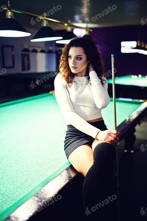Preview: Young curly girl posed near billiard table