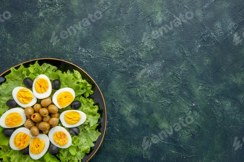 Preview: top view boiled sliced eggs with olives and green salad on dark background food health tea meal