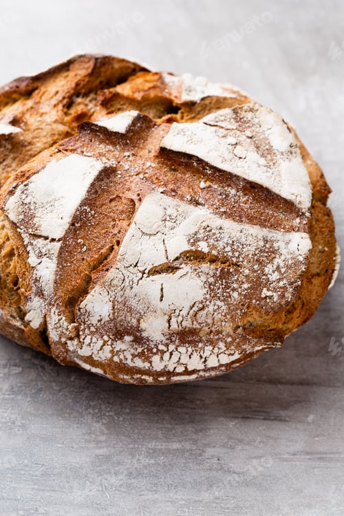 Preview: Freshly baked bread on dark gray kitchen table, top view.