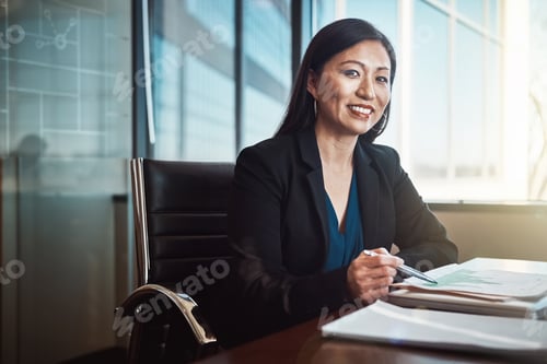 Preview: Businesswoman at Desk Reviewing Charts in Office
