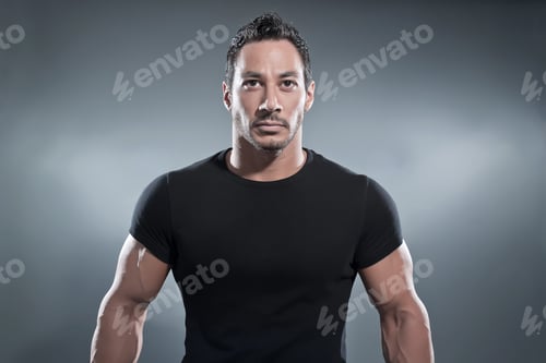 Preview: Combat Muscled Fitness Man Wearing Black Shirt And Pants. Studio Shot Against Grey.
