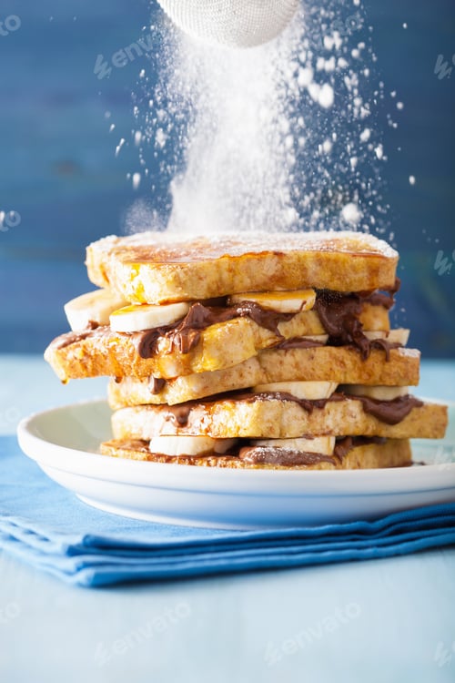 Preview: sprinkling powder sugar over french toasts with banana chocolate