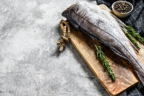 Preview: Fresh haddock fish carcass on the cutting Board. Gray background. Top view. Copy space