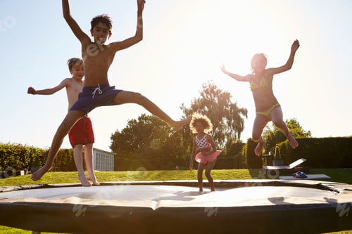 Preview: Group Of Children Having Fun Jumping On Outdoor Trampoline