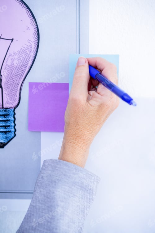 Preview: Creative businesswoman writing on post it in office