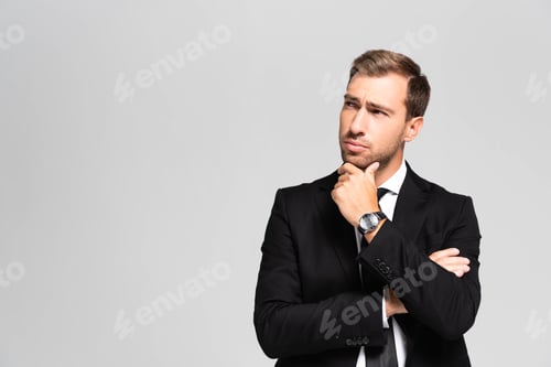 Preview: handsome and pensive businessman in suit looking up isolated on grey