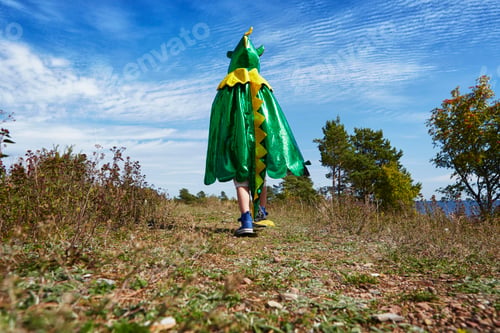 Preview: A child in a vibrant green dragon costume explores the great outdoors.