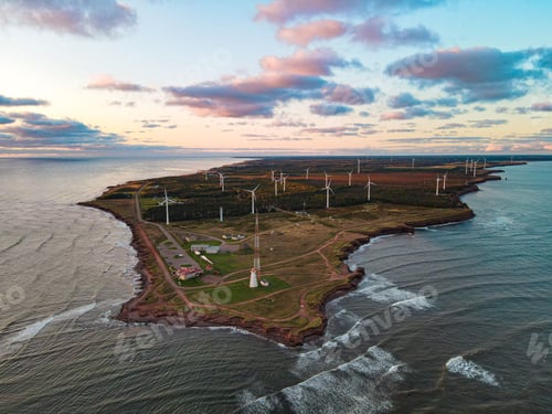 Preview: Beautiful aerial view of an island with wind turbines under the sunset sky with clouds