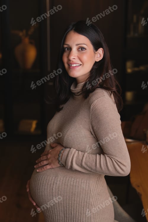Preview: Happy pregnant woman in casual dress at home