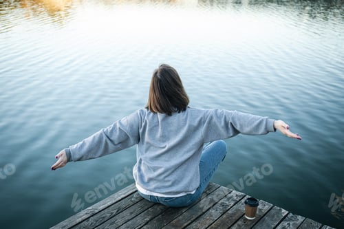 Preview: A young woman with a cup of coffee on the background of the river.