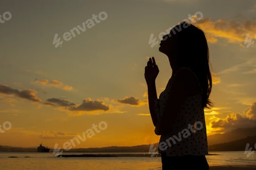Preview: silhouette of woman enjoying the sunset on the beach