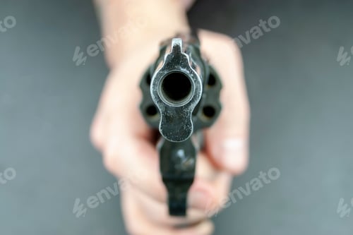 Preview: Hand is holding revolver, with barrel facing the camera
