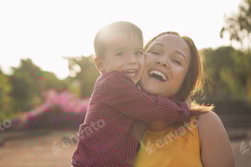 Preview: Happy young mother laughing with her son in her arms