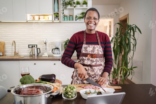 Preview: Smiling woman preparing healthy meal in modern kitchen