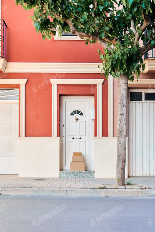 Aperçu: Facade of an orange-colored house with carton boxes on the door