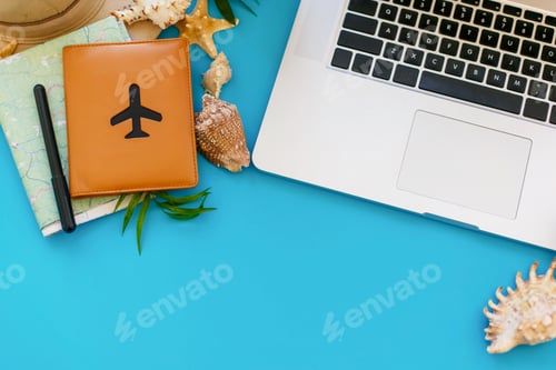 Preview: Laptop with empty screen, pineapple in sunglasses, passport, map, hat, on blue paper