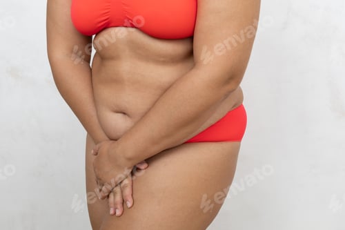 Preview: Unrecognizable overweight, fat adipose woman in red lingerie holding thighs and bikini zone after