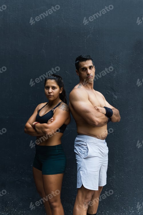 Preview: Serious Hispanic sportive couple near wall