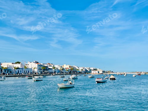 Preview: Canal de Tavira . Small boat cruising tranquil green river.