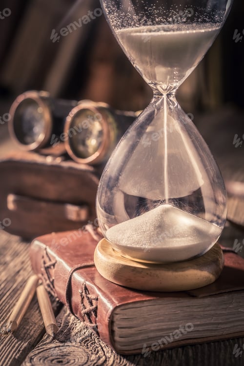 Preview: Closeup of hourglass and journal with compass and binocular