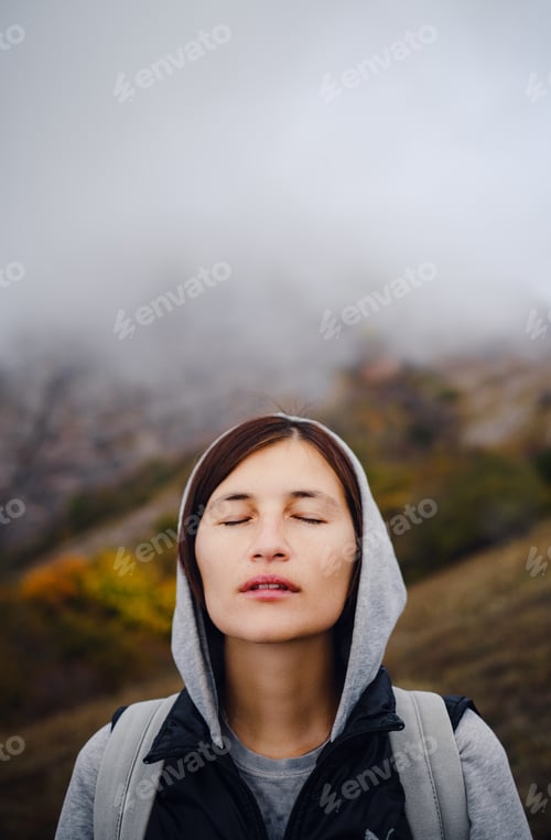 Preview: Asian travel woman stands by the mountain. Cold weather