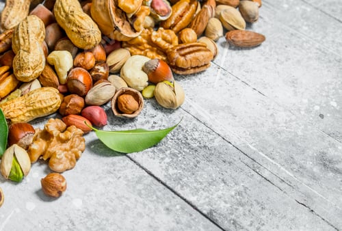 Preview: Nuts background. Different kinds of nuts with leaves.