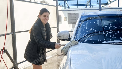 Preview: Young woman washing car with shampoo foam and brush. Automobile care, transport cleaning, dirty car.