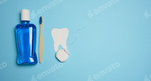 Preview: Plastic bottle with mouthwash, wooden toothbrush on blue background