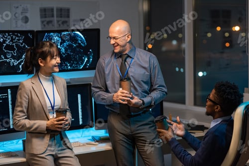 Preview: Three happy colleagues with drinks having discussion in working environment