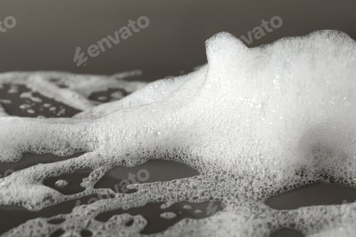Preview: Fluffy bath foam on grey background, closeup
