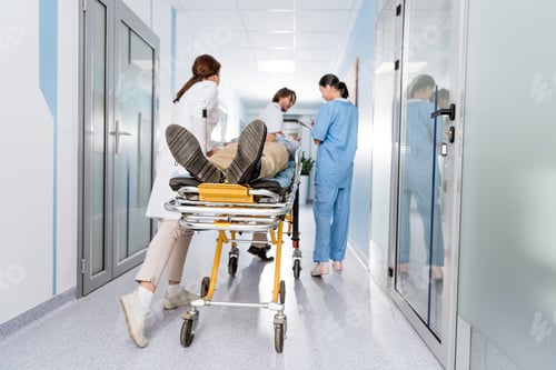 Preview: Doctors and nurse transporting unconscious patient on gurney