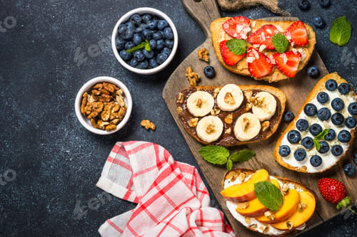 Preview: Sweet toast assortment with fresh fruit and berries on black.