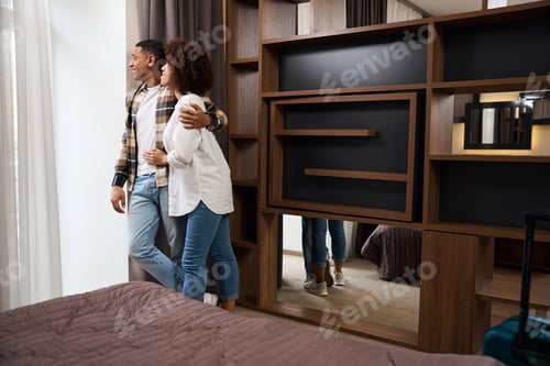 Preview: Multiracial young family settled in a cozy hotel room