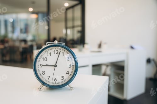 Preview: A blue alarm clock sits on a white desk in a room