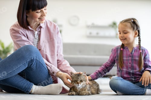 Vista previa: Mother and daughter bonding while petting their cat at home