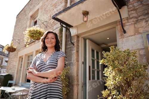 Preview: Female restaurant pub owner standing outside her business
