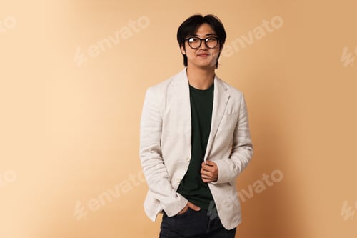 Preview: Portrait of handsome Asian businessman in glasses on beige background. Space for text