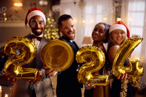 Visualização: Felizes amigos multirraciais com balões dourados de 2024 na festa de Ano Novo em casa, olhando para a câmera.