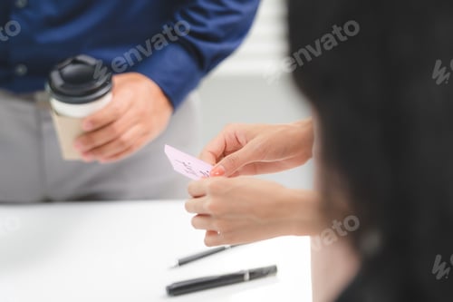 Preview: Group of male and female business people discussing over documents and data in conference room