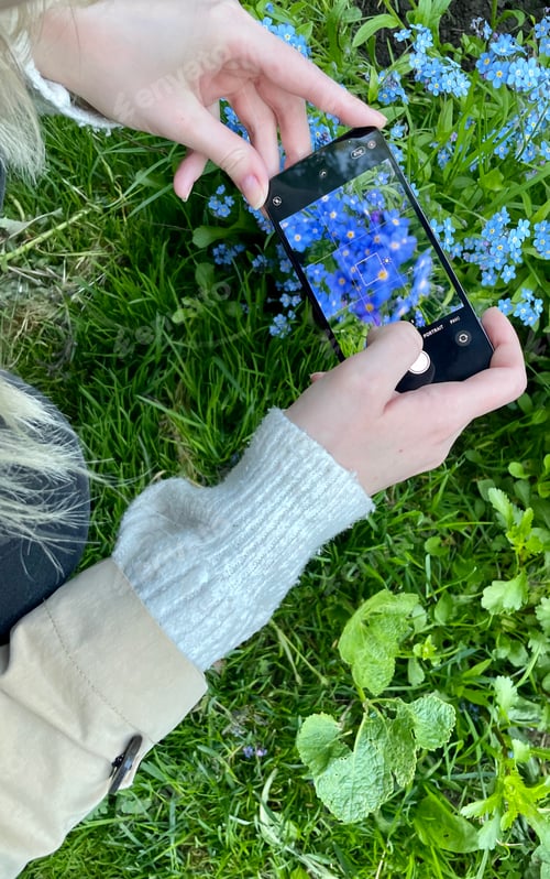 Preview: A girl takes pictures of flowers, plants on her mobile phone