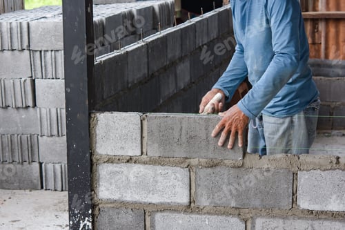Preview: Bricklayer laying bricks on mortar